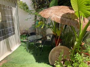 a small patio with a table and chairs and plants at Elinor's Secret Suite in Sulam Tsor
