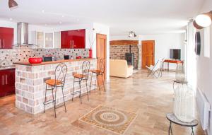 cocina y sala de estar con armarios y sillas rojos en Nice Home In St Cirgues De Prades With Private Swimming Pool, Can Be Inside Or Outside, en Jaujac