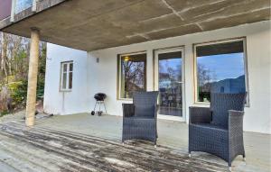 Un porche con dos sillas y una cámara. en Amazing Apartment In Forsand With House Sea View, en Helle