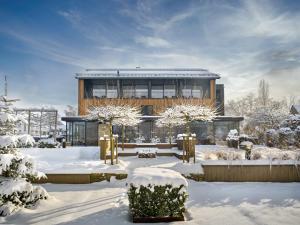 a building in the snow with snow covered trees at Hotel Bütgenbacher Hof in Butgenbach