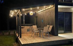 a patio with a table and chairs on a deck at night at Cozy Home In Sianowo With Wifi in Sianowo +6 photos