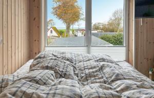 a bed in a room with a large window at 1 Bedroom Beautiful Home In Samsø in Kolby Kås +5 photos