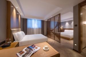 Postel nebo postele na pokoji v ubytování Qingdao Xinduxin Manxin Hotel + 51 fotografií