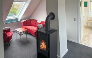 a living room with a fireplace and a red couch at 7 Bedroom Stunning Home In Samsø in Kolby Kås