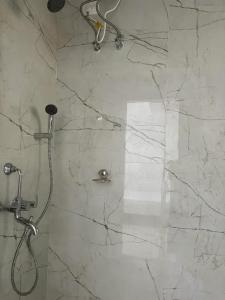 a shower in a bathroom with a marble wall at Stay Place in kolkata