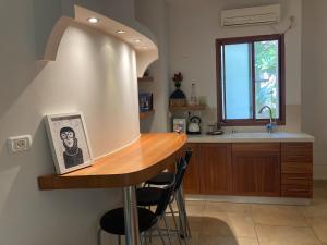 a kitchen with a table with chairs and a sink at Elinor's Secret Suite in Sulam Tsor