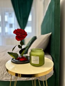 a table with a rose and two candles on it at Romantic studio AxS in Floreşti