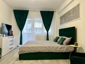 a bedroom with a bed with green curtains at Romantic studio AxS in Floreşti