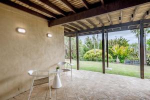 a patio with two chairs and a table on a patio at Curragudde Cove - Pambula Beach in Pambula Beach