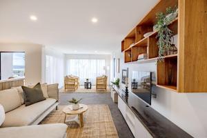 a living room with a couch and a table at Curragudde Cove - Pambula Beach in Pambula Beach