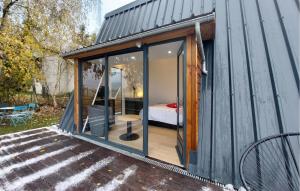 Una pequeña casa con puertas de cristal y un dormitorio. en Nice Home In Herry With Heated Swimming Pool, en Herry 8 fotos más