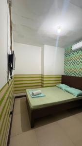 a room with a bed and a television in it at ZIUR INN in Laoag