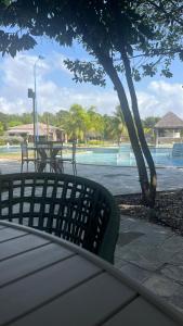 a park bench with a view of the water at Flat Resort ILOA in Barra de São Miguel