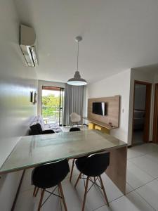 a kitchen and living room with a table and chairs at Flat Resort ILOA in Barra de São Miguel