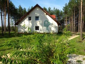 a small white house with a tree painted on it at Familienpark Senftenberger See in Senftenberg
