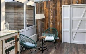 two chairs in a kitchen with wood paneling at Cozy Home In Scharendijke With Private Swimming Pool, Can Be Inside Or Outside in Scharendijke