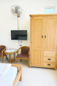ein Zimmer mit einem Bett und einem Tisch und einem Schrank in der Unterkunft Hạ Vy Hotel Hồ Chí Minh in Ho-Chi-Minh-Stadt