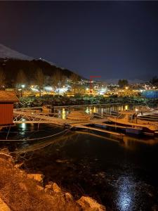a marina at night with boats in the water at Strandveien apartment in Narvik