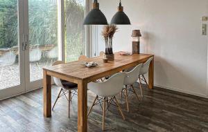 a dining room with a wooden table and chairs at Cozy Home In Scharendijke With Private Swimming Pool, Can Be Inside Or Outside in Scharendijke