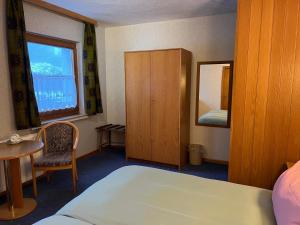 ein Schlafzimmer mit einem Bett, einem Tisch und einem Spiegel in der Unterkunft Pension Mountain View Sauerland in Winterberg + 62 Fotos