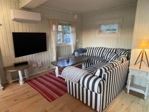 a living room with two striped couches and a table at Furuheimen - cabin by the sea in Skjeberg in Skjeberg