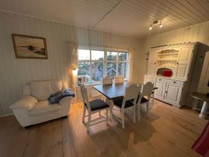 a living room with a table and chairs and a couch at Furuheimen - cabin by the sea in Skjeberg in Skjeberg