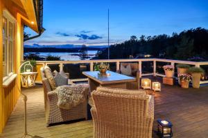 a patio with chairs and a table on a deck at Furuheimen - cabin by the sea in Skjeberg in Skjeberg