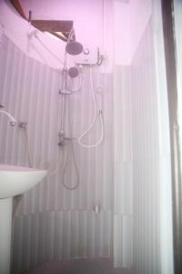 ein weißes Badezimmer mit Dusche und Waschbecken in der Unterkunft Wood Aura Ella in Ella