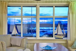 a living room with a large window with a sail boat in a room at Furuheimen - cabin by the sea in Skjeberg in Skjeberg +30 photos