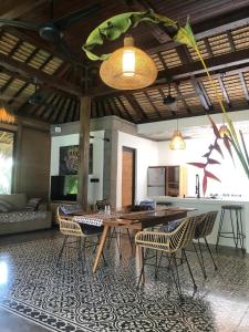 een kamer met een tafel en stoelen en een keuken bij Heliconia Joglo House in Sempidi