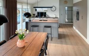 a kitchen with a wooden table with a vase of flowers on it at 3 Bedroom Awesome Home In Haderslev in Kelstrup Strand