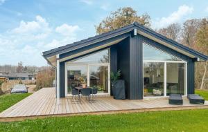 a black shed with a table and chairs on a deck at 3 Bedroom Awesome Home In Haderslev in Kelstrup Strand +7 photos