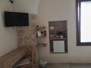 a living room with a television on a stone wall at b&b DA GINO in Lecce