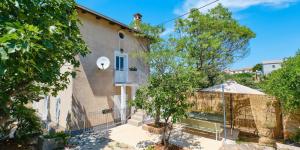 a house with a fence in front of it at Pino 1 in Veli Lošinj