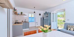 a kitchen and living room with a couch and a table at Pino 1 in Veli Lošinj