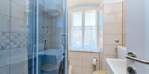 a bathroom with a shower and a sink and a window at Pino 1 in Veli Lošinj
