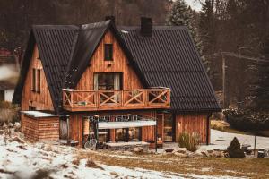 a large wooden house with a balcony on it at Rycerki Dom na Szlaku in Rajcza