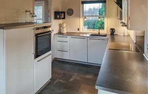 a kitchen with white cabinets and a black counter top at 3 Bedroom Beautiful Home In Hjørring in Mejeriby