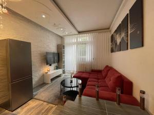 a living room with a red couch and a table at Lipno Pearl Terasa in Lipno nad Vltavou