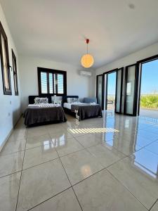 a large room with two beds and a couch at Aurora Gardens Villa Spacious 3 Bedroom in Protaras in Paralimni
