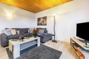 un soggiorno con un divano e una TV di Ferienwohnung, 55qm a Herscheid