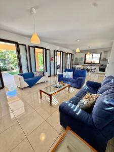 a large living room with blue couches and a table at Aurora Gardens Villa Spacious 3 Bedroom in Protaras in Paralimni
