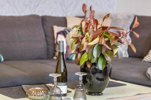 un tavolo con una bottiglia di vino e un vaso di fiori di Ferienwohnung, 55qm a Herscheid