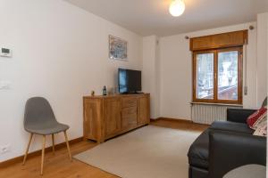 a living room with a couch and a television at Sweet Loft in Sottoguda