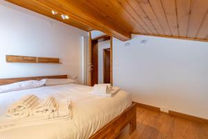 a bedroom with a large bed with wooden floors at Sweet Loft in Sottoguda