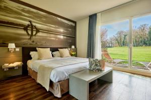 Un dormitorio con una cama grande y una ventana grande. en Saint Malo Golf Resort, en Le Tronchet 37 fotos más