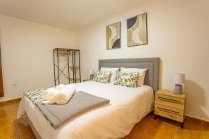 a bedroom with a large bed and a night stand at A Casa dos Amigos - Termas São Vicente in Penafiel +22 photos