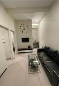 ein Wohnzimmer mit einer Couch und einer Uhr an der Wand in der Unterkunft Fan Family Bromo Homestay in Ngadisari + 20 Fotos