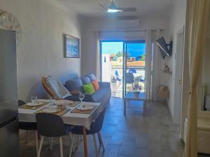 a living room with a blue couch and a table at Arena Sol by HelloApartments in Puerto de Santiago