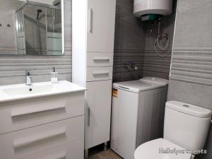 Un baño con lavabo, inodoro y espejo. en Ocean View Playa la Arena by HelloApartments, en Puerto de Santiago 21 fotos más